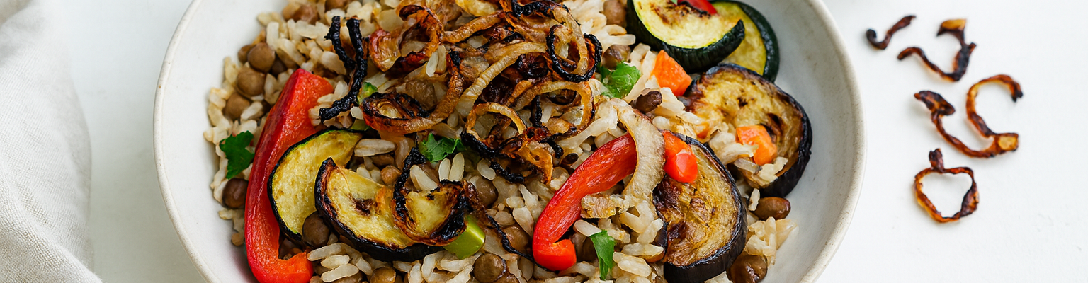 Lebanese mujadara with lentils, rice, caramelised onions, zucchini, capsicum, and eggplant served with yoghurt.