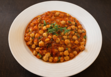 Chickpea stew in a tomato-based sauce, garnished with fresh herbs.